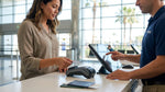 Customer handing a credit card to an agent at a car hire desk in California