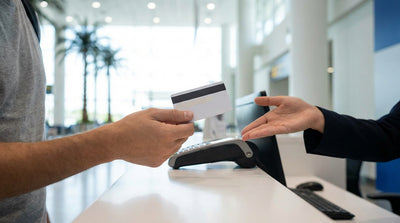 A customer hands a credit card to an agent at a car hire desk at the Los Angeles airport