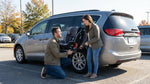 A parent secures a toddler in a child safety seat in the back of their Pennsylvania car hire vehicle