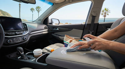 A person carefully cleans the leather seats of their California car hire with a soft microfiber cloth