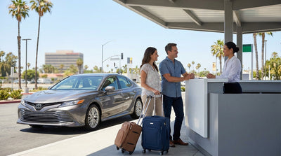 A convertible car hire driving on a sunny coastal highway in California with ocean views