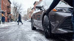 Black car rental with winter tires driving on a snowy New York road