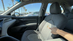 Person inspecting a spilled coffee stain on the interior seat of a California car rental