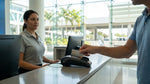 A person paying for their car hire with a credit card at a rental desk in Miami Airport