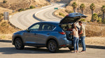 A silver SUV car rental driving on a sunny California highway with mountains in the background
