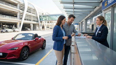 A person driving a car rental on a scenic road through the rolling hills of Pennsylvania