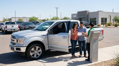 A silver car hire driving down a scenic highway through the rolling hills of Texas under a bright blue sky