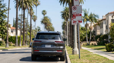 A car hire is parked on a Los Angeles street next to a confusing red and white street-sweeping parking sign