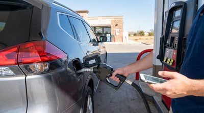 A person looking at the fuel options on a pump at a Texas gas station before refueling their car hire