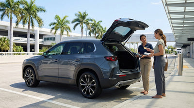 A blue convertible car rental driving down a sunny street in Miami lined with palm trees and Art Deco buildings
