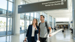 A white shuttle bus arriving at the car rental pick-up point outside Miami Airport Terminal F