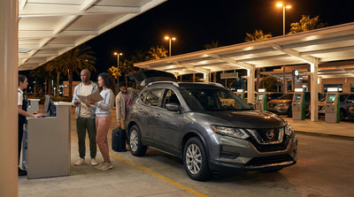A traveler with luggage walking through a quiet Orlando airport at night to collect their car hire