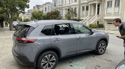 A car rental parked on a San Francisco street with a shattered passenger side window