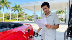 Person pumping gas into a modern car rental at a sunny Florida gas station with palm trees