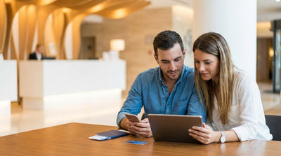 A modern car hire sedan driving across the Brooklyn Bridge towards the iconic New York City skyline at sunset