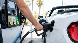 Close up of a fuel nozzle pumping gas into a car rental vehicle at a gas station in California