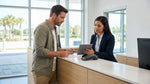 Person receiving keys for a car rental from an agent at a bright service desk in Florida