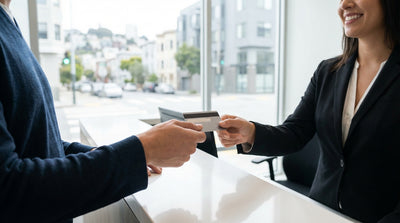 A person stands by their car hire overlooking the sunny San Francisco skyline and Golden Gate Bridge