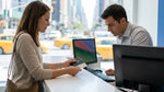 Person handing a passport card to an agent at a car rental desk in New York