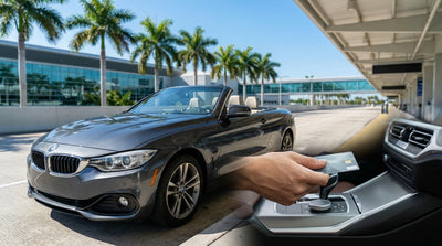A red convertible car hire parked on a sunny Ocean Drive in Miami with classic Art Deco hotels