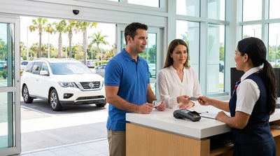 A person's hands holding car hire keys and a credit card in a sunny Florida parking lot