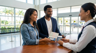 A happy traveler receives keys for their car hire from an agent at a desk in the United Estates