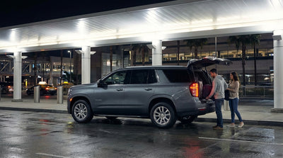 A person walks through a brightly lit Los Angeles car hire lot at night to find their vehicle