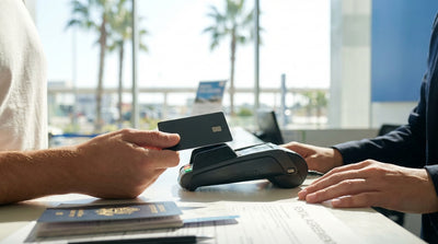 A person holding a credit card at a car rental counter in Orlando, Florida