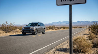 A car hire vehicle driving down a long, empty desert highway with mountains in the distance near Las Vegas