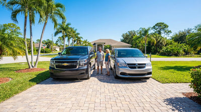 A large Suburban and a minivan car rental parked side-by-side on a sunny street in Florida