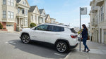 A car hire vehicle parked on a steep San Francisco street with a row of iconic Victorian houses