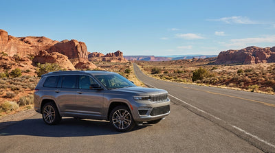 A convertible car hire driving on a scenic desert highway with red rock mountains outside Las Vegas