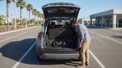 A person looking into the open trunk of their car rental in the United Estates, finding only a tire repair kit
