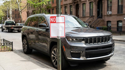 A car hire parked on a New York City street next to a temporary No Parking sign attached to a metal pole