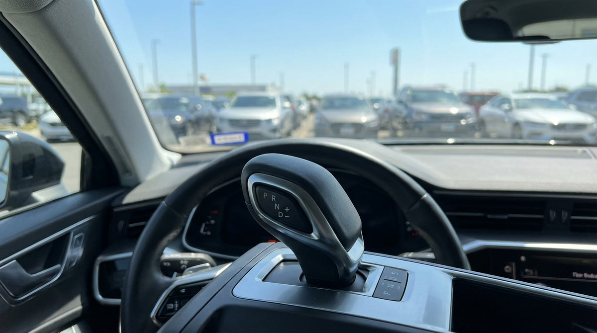 A driver's hand on an automatic gear shift inside a car rental in the United States