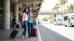 A car rental shuttle bus picking up passengers with luggage outside the LAX arrivals terminal