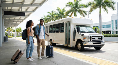 A car rental shuttle bus waits for passengers under palm trees at a sunny Miami airport curb