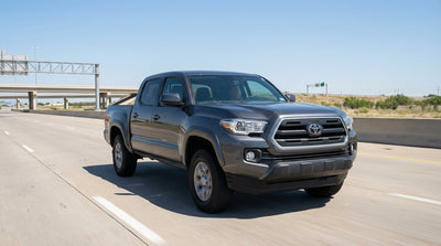 A sedan from a car rental service on an open highway road trip through the sunny Texas landscape