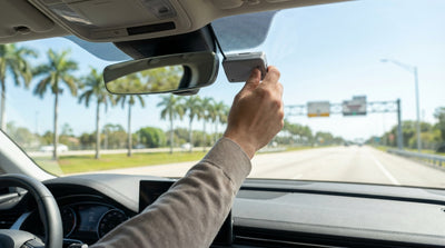 A car hire driving on a sunny Florida highway under an electronic toll gantry