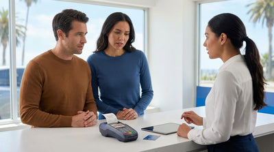 A driver stands by their car hire in California, looking concerned at a credit card