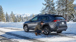 Car rental equipped with snow chains driving along a snowy mountain road in California