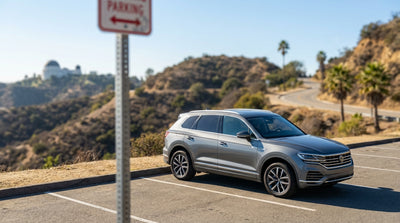 A car hire parked at Griffith Observatory with a view of the Los Angeles skyline at sunset