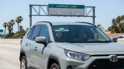 A car hire driving over the Golden Gate Bridge in San Francisco on a sunny day with city views