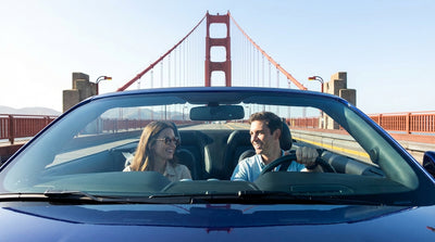 A rental car driving across the Golden Gate Bridge in San Francisco on a sunny day