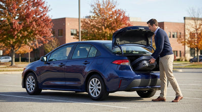 A red car rental driving down a tree-lined highway in the Pennsylvania countryside during autumn