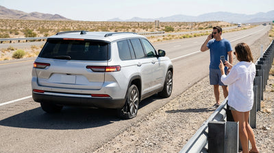 A car hire with a shredded tire is pulled over on the shoulder of the I-15 highway near Las Vegas