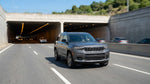 A car hire merges into traffic at the entrance to a brightly lit tunnel in Pittsburgh, Pennsylvania