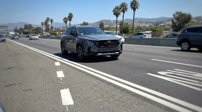 A car hire on a multi-lane California freeway driving alongside the double white lines of the carpool lane