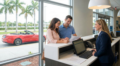 A white convertible car hire driving down a scenic coastal road in Florida with palm trees