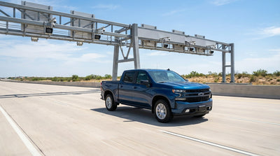 A car rental with a toll tag on its windshield drives down a multi-lane highway in Texas